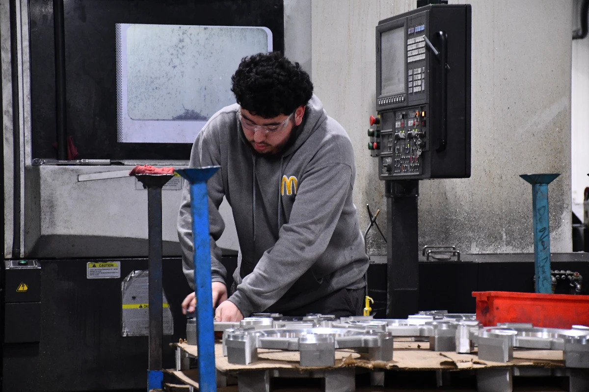 Machinist loading castings at a CNC machining center