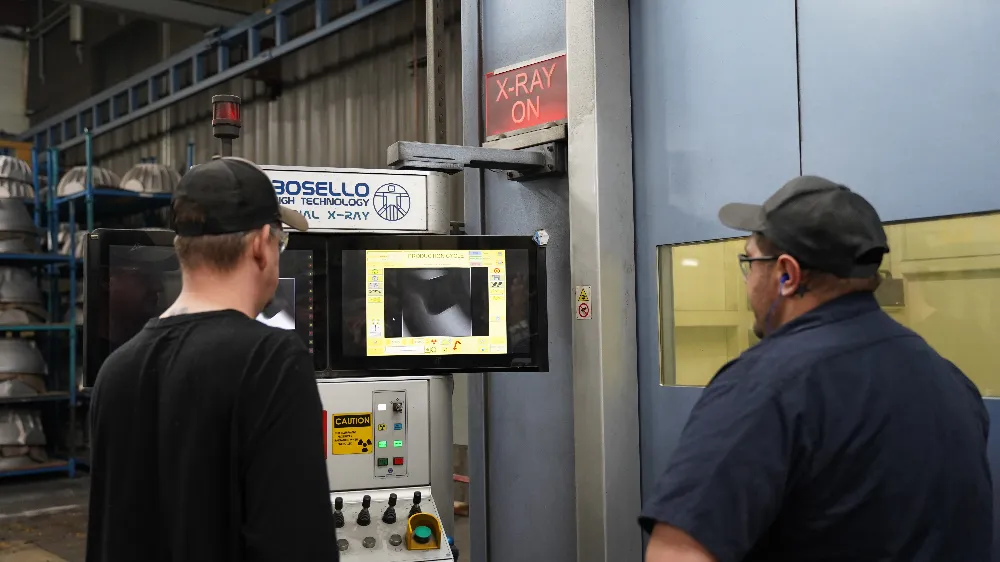 Technicians reviewing a real-time X-ray image of a casting